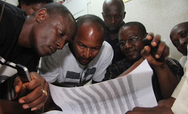Families reading through the manifest of the plane crash